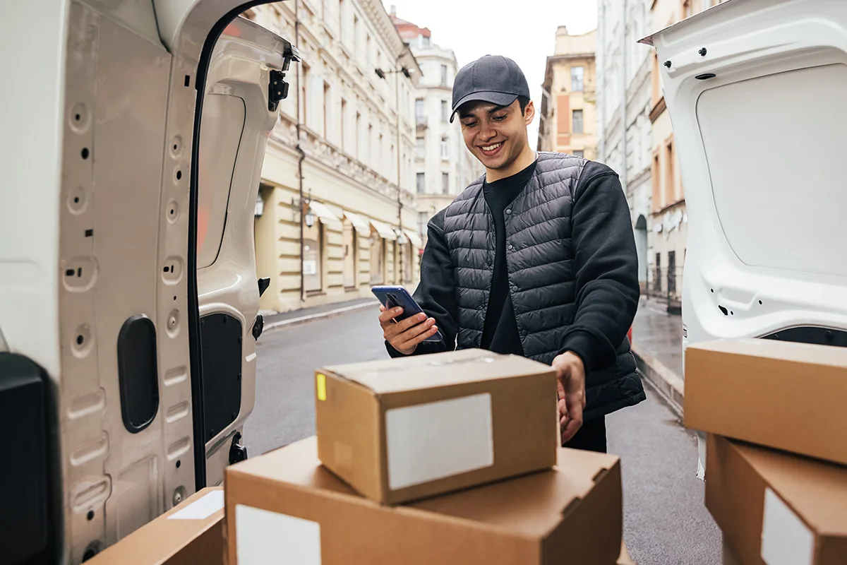 Coursier consultant sa prochaine course sur smartphone — logiciel de transport pour coursiers